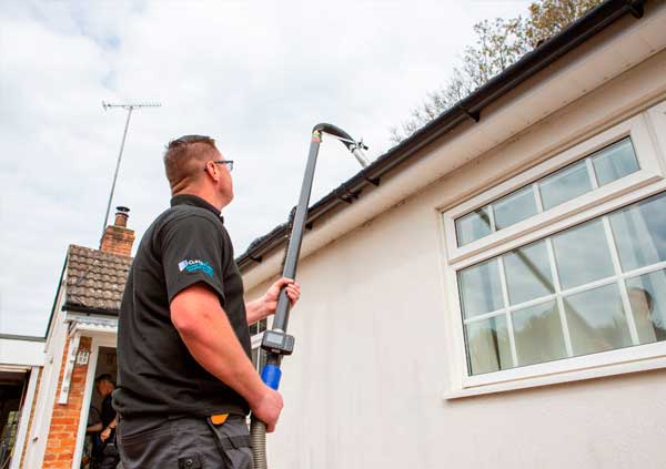 Operator using a remote gutter cleaning tool