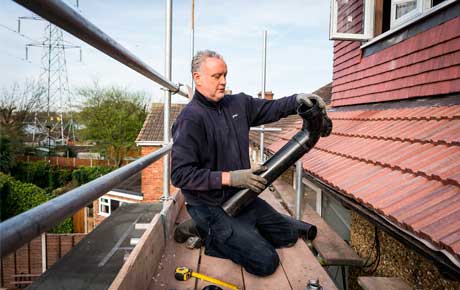 Operator repairing a black plastic gutter