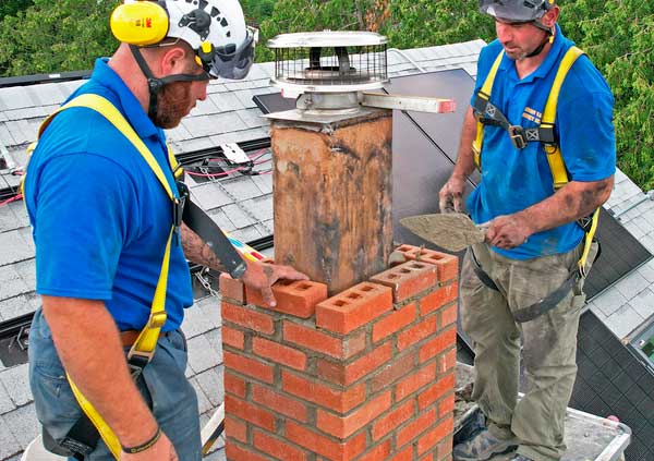 Operators repairing a damaged chimney