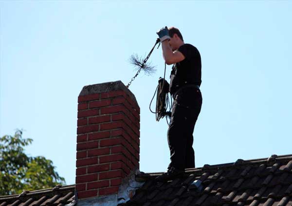 Operator cleaning the inside of a chimney