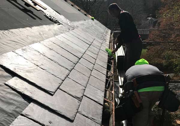 Operators installing a new gutter and tiling