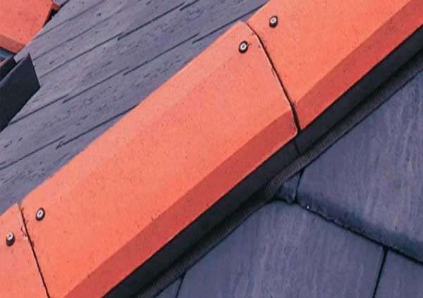 Red ridge tiles on a black roof