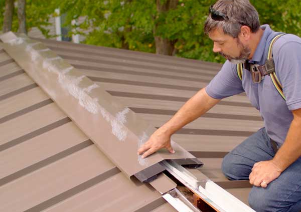 Operator repairing the ridge tiles of a roof