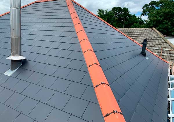 Roof with black slates and red ridge tiles