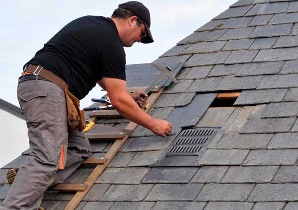 Operator replacing some slates of a roof