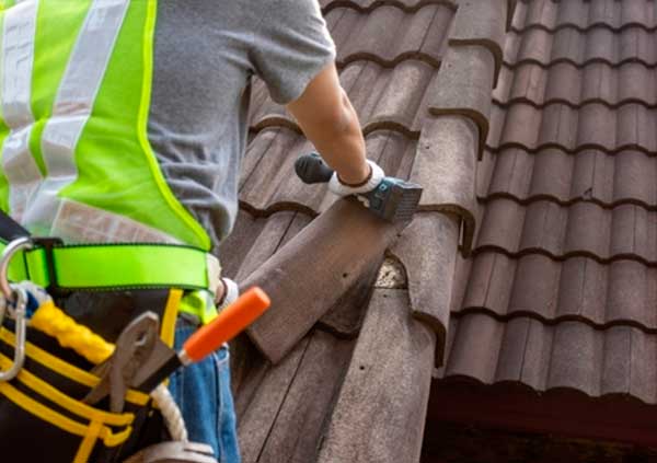 Worker Replacing Dry Verge Caps of a roof