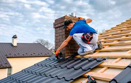 Operator replacing black tiles on a roof