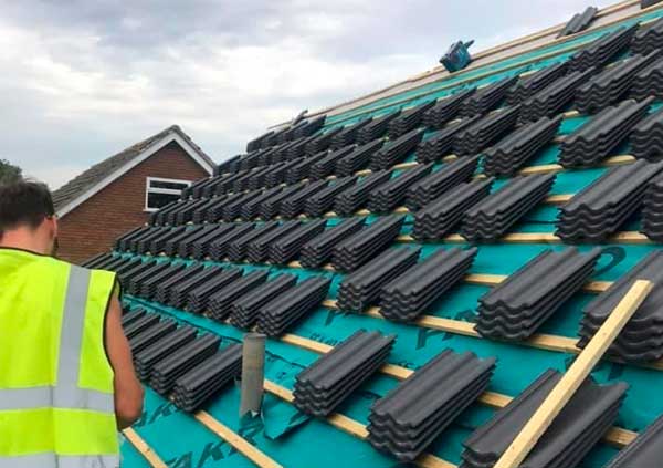 Roof being re-roofed with black tiles