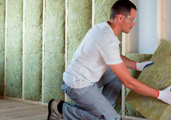 Operator installing the insulation in an attic